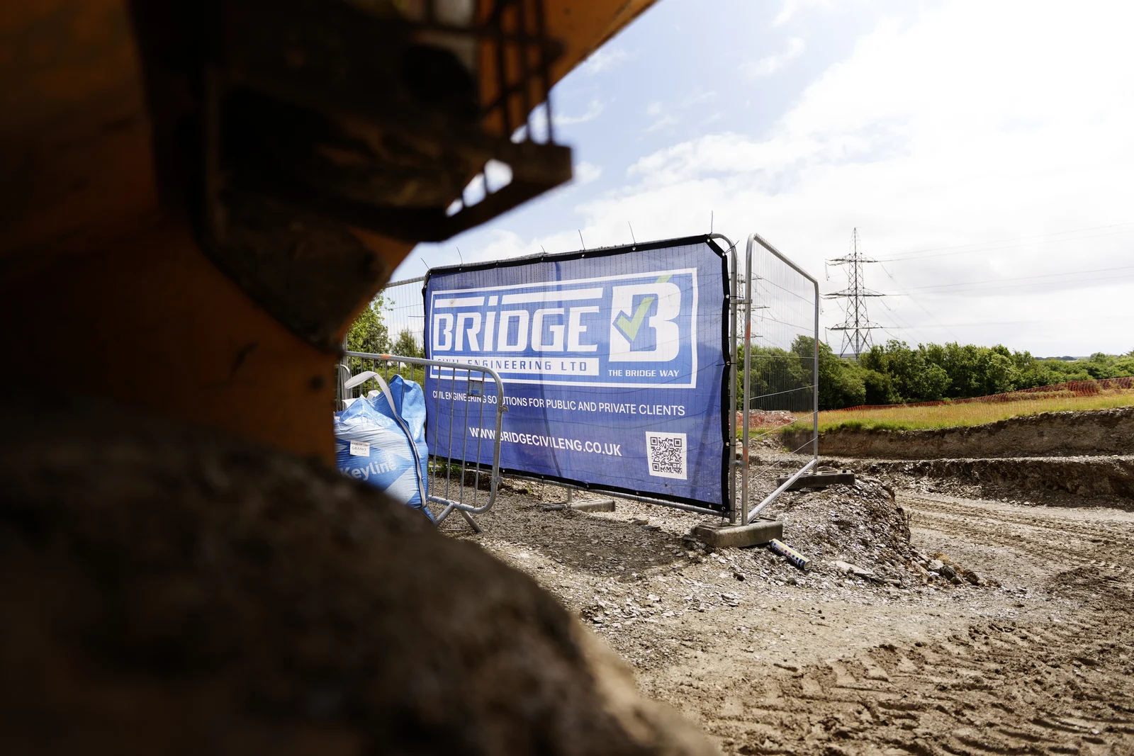 Bridge Civil Engineering banner on site fencing beside excavation works