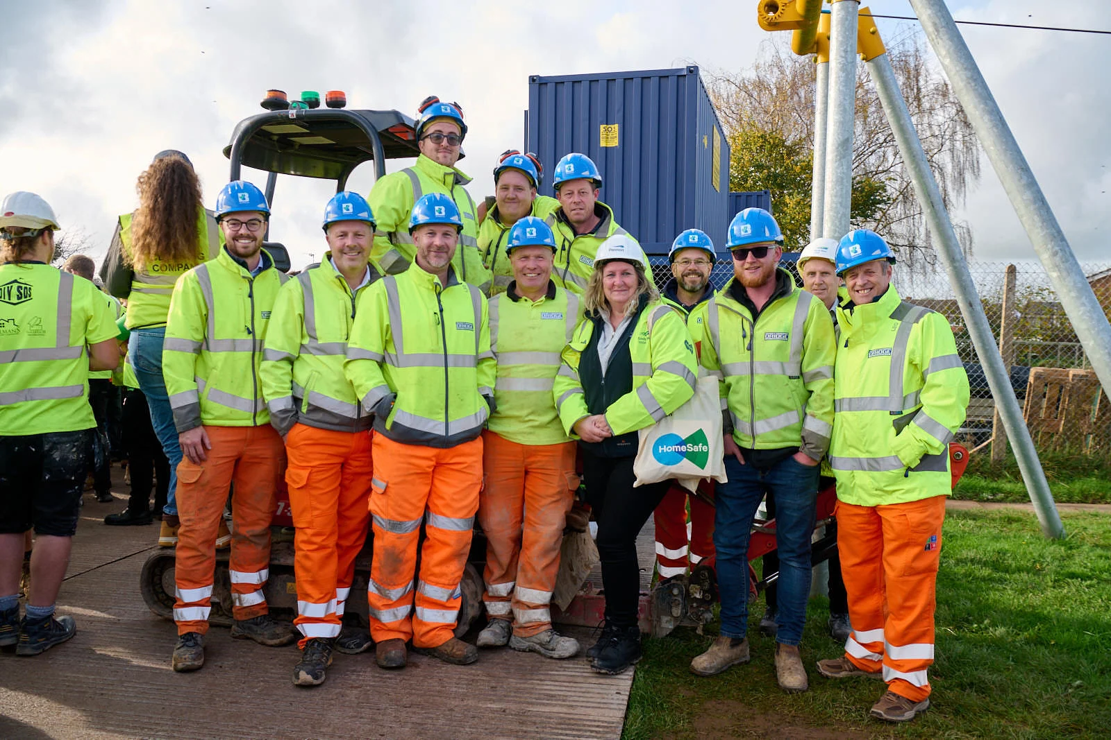 Bridge team in high-visibility clothing and hard hats gathered on site