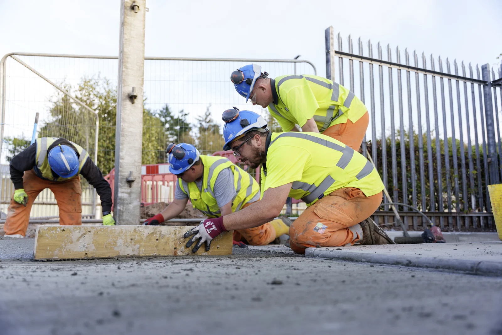 Bridge operatives levelling concrete beside an existing pavement