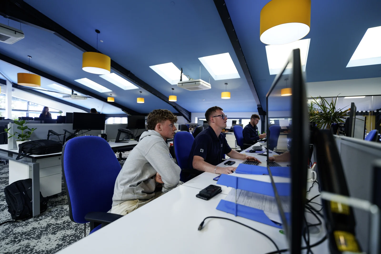 Bridge colleagues working together at computer desks in the office