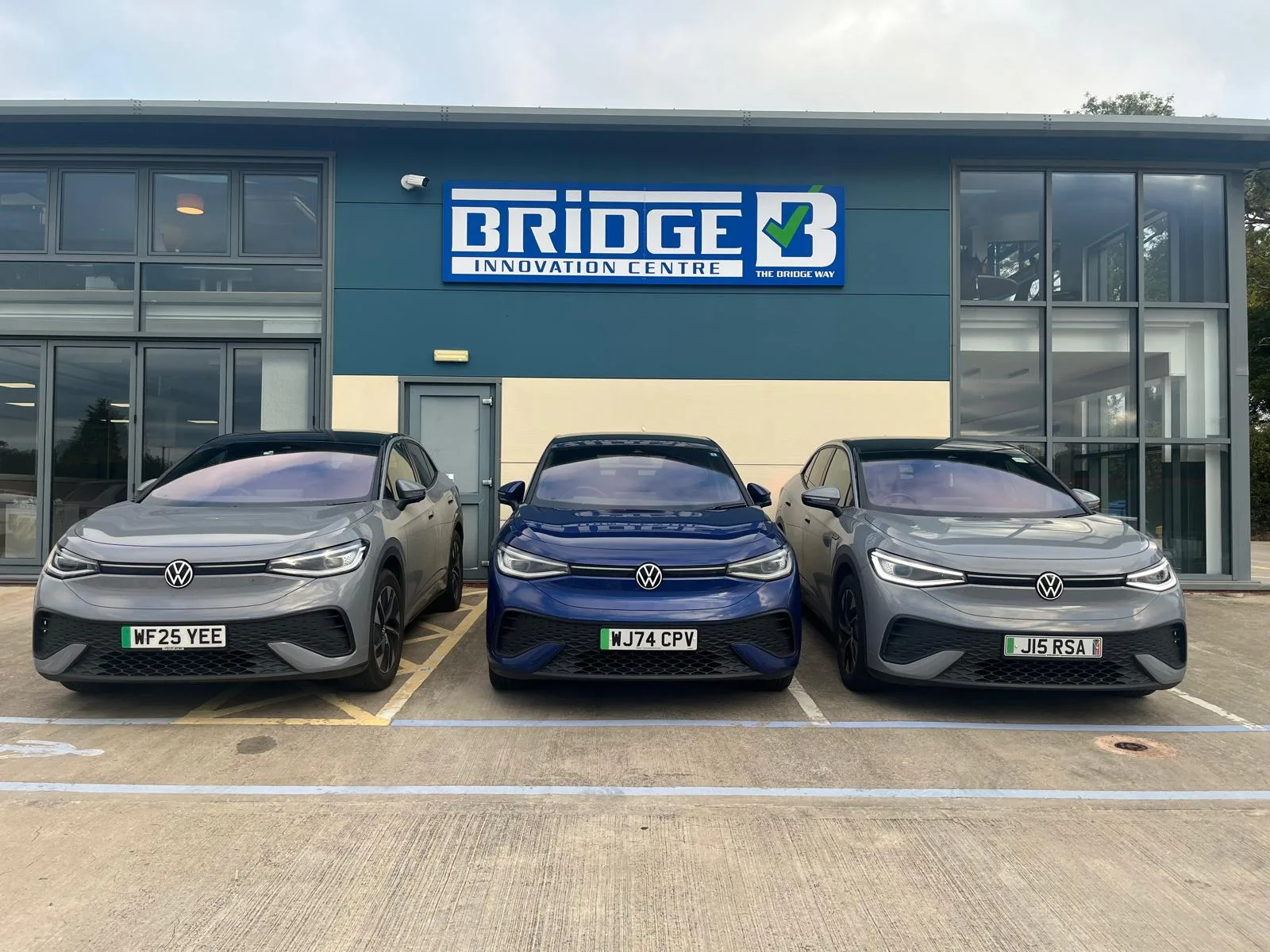 Three Volkswagen electric vehicles parked outside the Bridge Innovation Centre