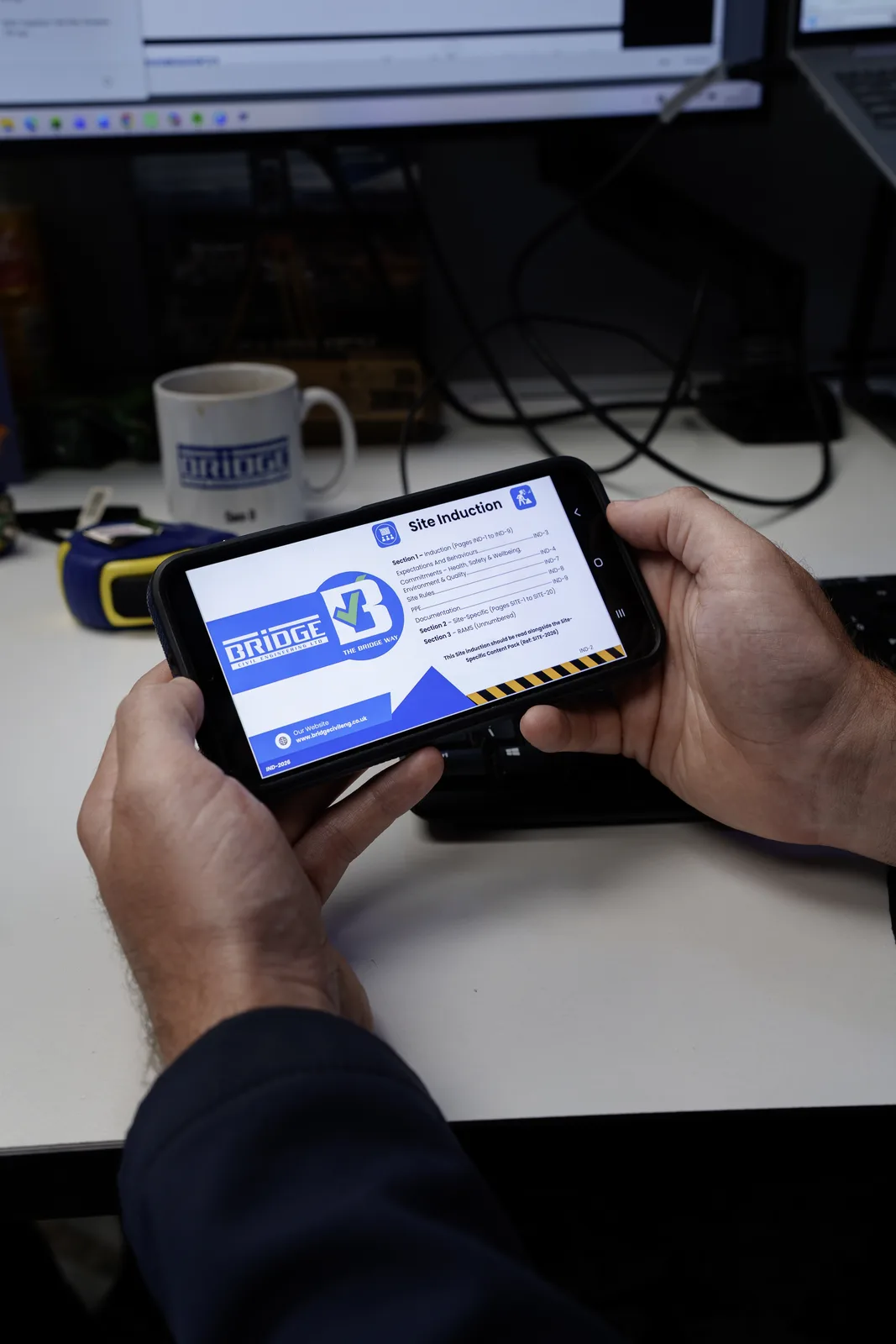 Bridge Civil Engineering site induction guide displayed on a smartphone held horizontally